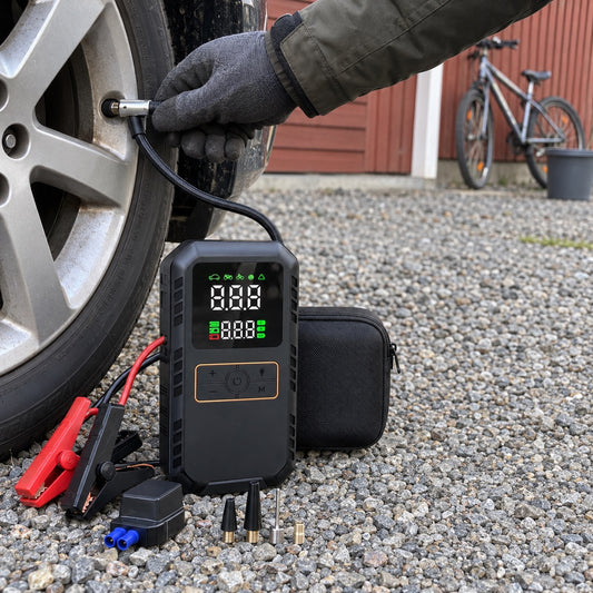 Händer som pumpar bildäck med luftslangen från en svart startbooster