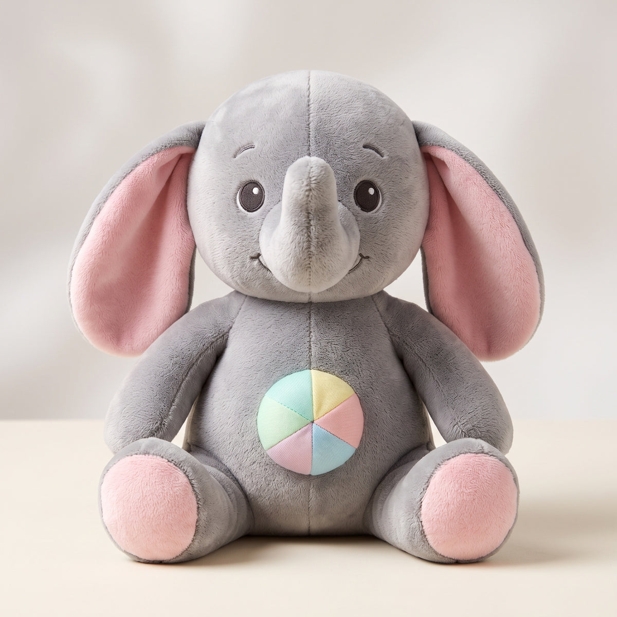 Grå plysch-elefant med pastellboll