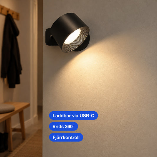 Närbild av en svart rund vägglampa med räfflad inre reflektor på en vägg i en hall