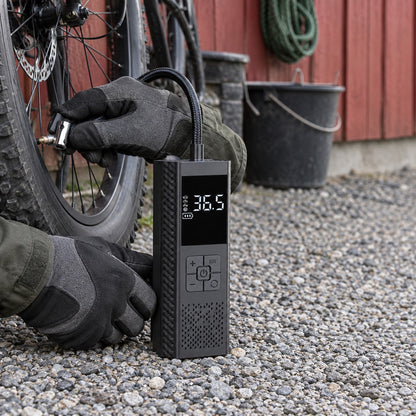 Händer som pumpar ett cykeldäck med den svarta däckpumpen