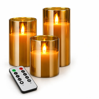 Tre flamlösa LED-ljus i amberglas av olika höjd med vit fjärrkontroll på vit bakgrund