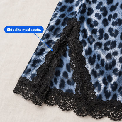 Närbild på sidoslits med svart spets och spetskant längs fållen på blått leopardnattlinne
