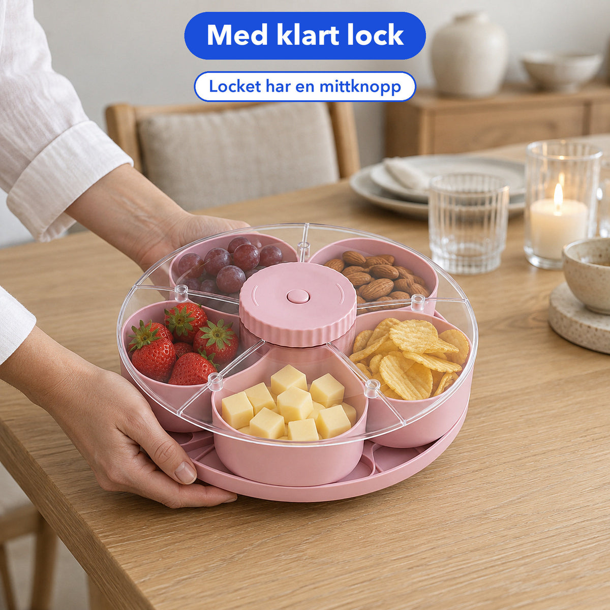Rosa snacksbricka med klart lock och mittknopp som ställs ned på ett dukat bord